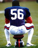 Lawrence Taylor Sitting on Football and Helmet Vertical Photo