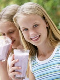 Two Girls Drinking Berry Smoothies Photographic Print by Louise Hammond