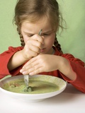 Girl Cutting a Broccoli Floret in Vegetable Soup Photographic Print by Ulrike Koeb