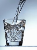 Pouring Water into a Glass Photographic Print by Bodo A. Schieren