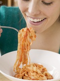Woman Eating Ribbon Pasta with Tomato Sauce Fotografisk tryk Woman Eating Ribbon Pasta with Tomato Sauce Fotografisk tryk