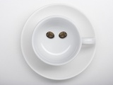 A Coffee Cup with Two Coffee Beans Making a Smiley Face Photographic Print by Jean Gillis