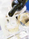 White Wine Pouring from Bottle into Glass; White Background Photographic Print by Linda Burgess