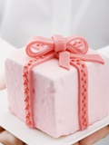 Hands Holding Cake with Marzipan Ribbon Photographic Print