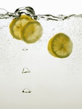 Lemon Slices in Water Photographic Print by Paul Blundell