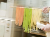 Chef Hurrying Through Kitchen with Ribbon Pasta on Wooden Spoon Fotografisk tryk Chef Hurrying Through Kitchen with Ribbon Pasta on Wooden Spoon Fotografisk tryk