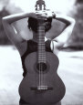 Mujer joven con guitarra acústica a la espalda