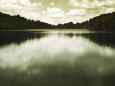 Water Reflecting Bordering Trees and Sky Photographie par Jan Lakey