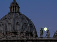 A Full Moon Rises over the Dome of St. Peters Basilica