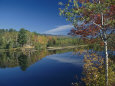 A Lake Surrounded by Trees Displaying the Colors of Autumn Fotografiskt tryck av Richard Nowitz