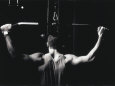Rear View of a Young Man Exercise on a Lateral Pull-Down Weight Machine Lámina fotográfica