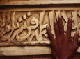 A Man Runs His Hand Over Arabic Script at the Famous Jama Masjid Lámina fotográfica